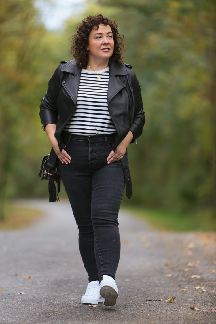 Alison Gary of Wardrobe Oxygen in a Universal Standard leather moto jacket, Everlane jeans, and an ALLSAINTS snakeskin print purse