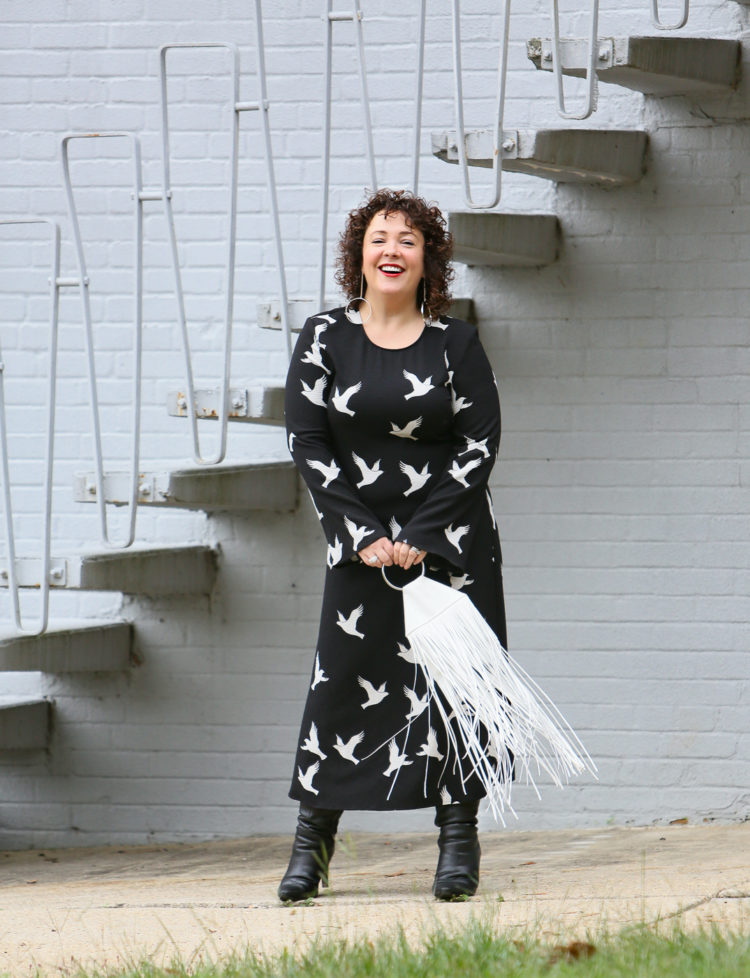 Black Stine Goya dress with white bird print styled with Kara Bags fringed purse and black heeled knee high boots