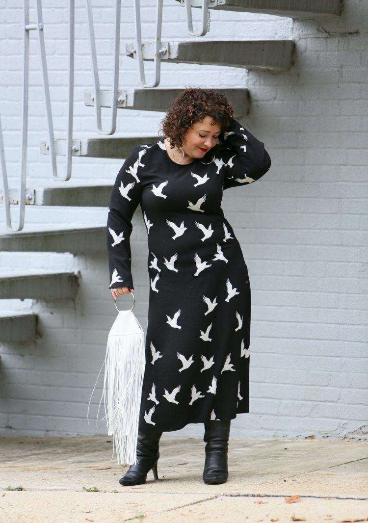 Black Stine Goya dress with white bird print styled with Kara Bags fringed purse and black heeled knee high boots