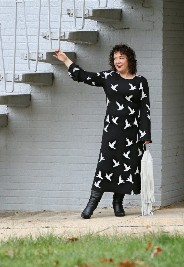 Black Stine Goya dress with white bird print styled with Kara Bags fringed purse and black heeled knee high boots