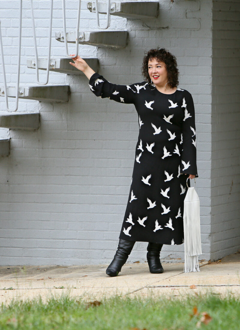 Black Stine Goya dress with white bird print styled with Kara Bags fringed purse and black heeled knee high boots