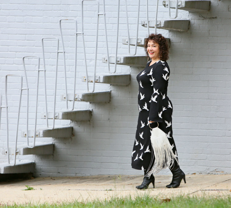 Black Stine Goya dress with white bird print styled with Kara Bags fringed purse and black heeled knee high boots