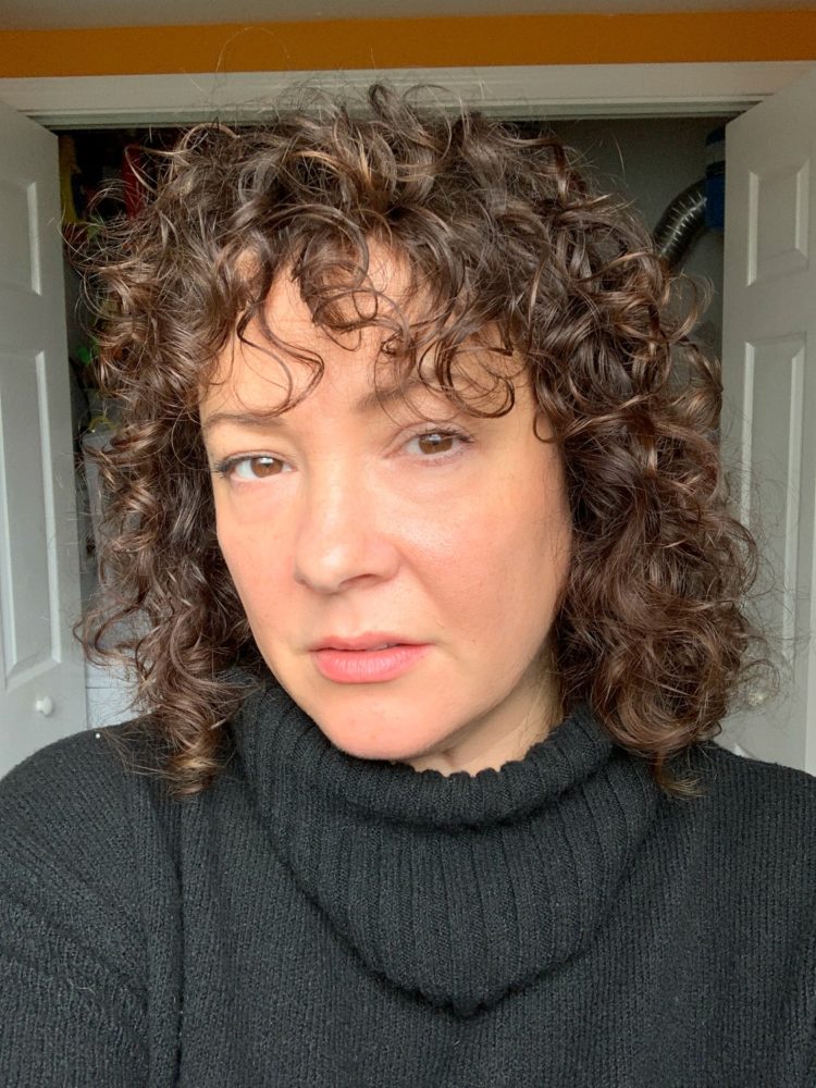 woman with curly brown shoulder length hair