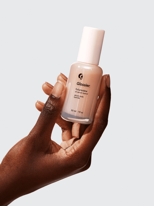 hand holding a bottle of Glossier Futuredew