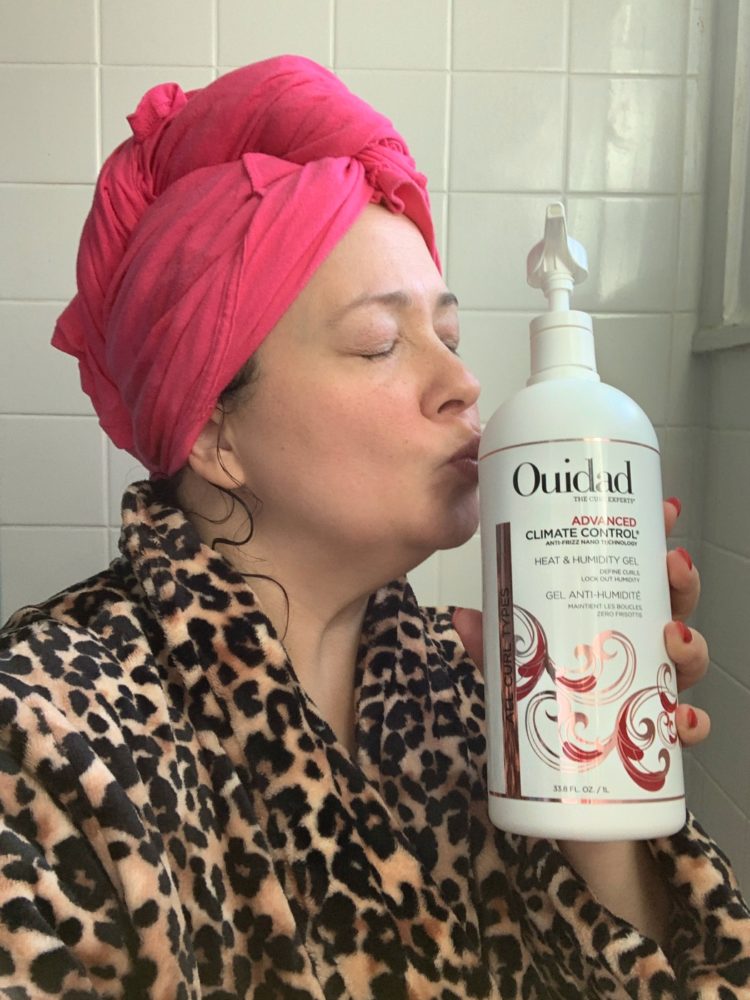 kissing a large bottle of Ouidad climate control gel