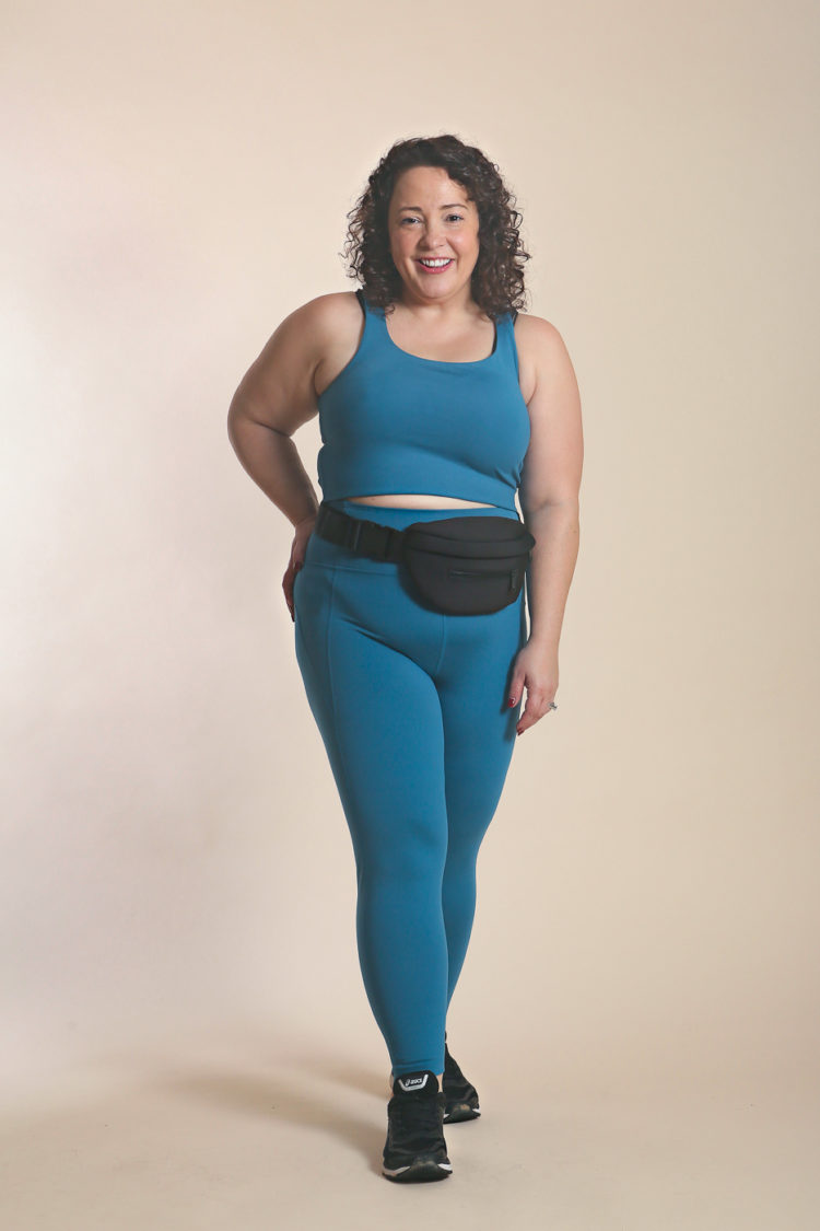 Woman in blue sports bra and leggings posing for the camera