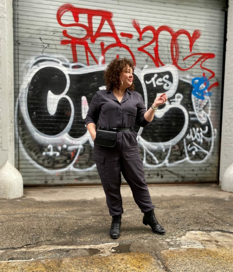 Alison of Wardrobe Oxygen in a gray boilersuit with a black leather belt bag and silver hoops from Jenny Bird