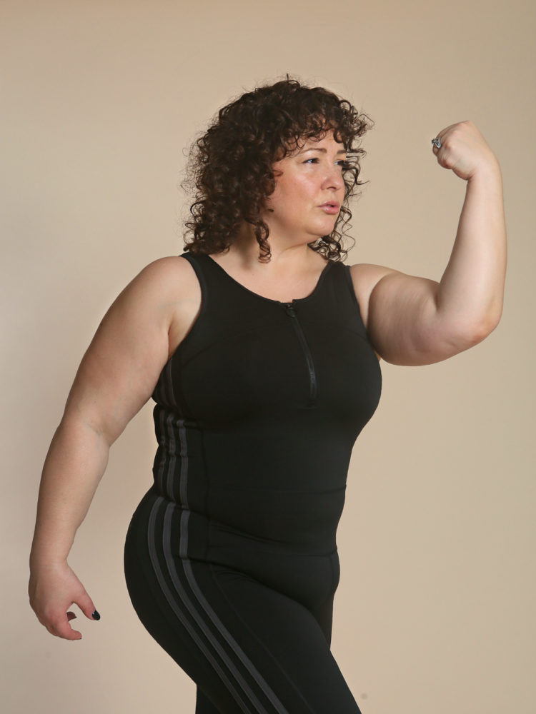 Woman flexing in a black unitard