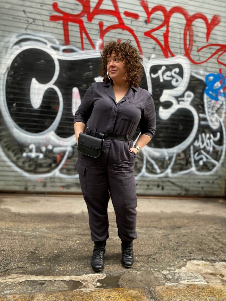 Alison of Wardrobe Oxygen in a gray boilersuit with a black leather belt bag and silver hoops from Jenny Bird