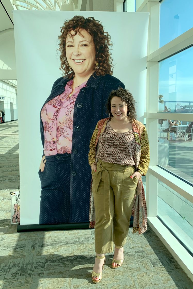 Alison Gary at a cabi conference, standing in front of a huge poster of herself as a model for the fashion brand.