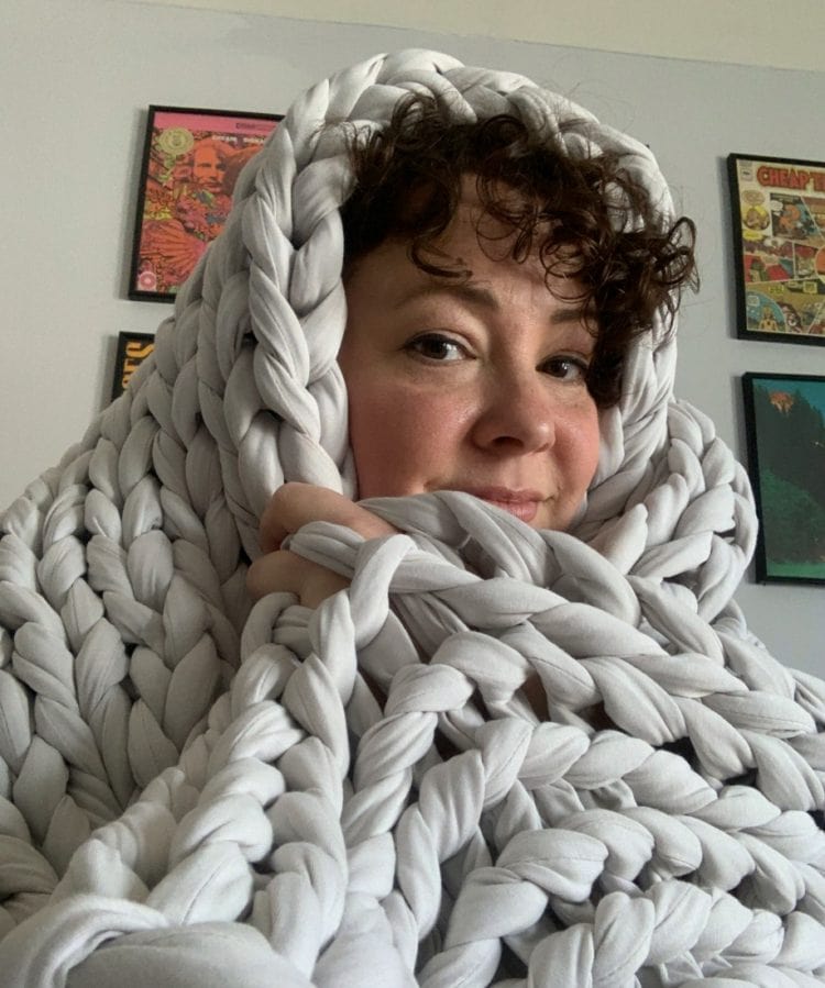 alison wrapped up in a pale gray wide knit blanket called the tree napper