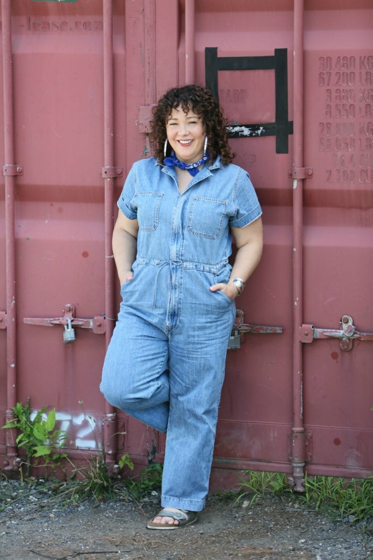 Woman in a short sleeve denim jumpsuit from Levi's styled with a blue bandana, silver Jenny Bird hoops, and silver Birkenstock sandals