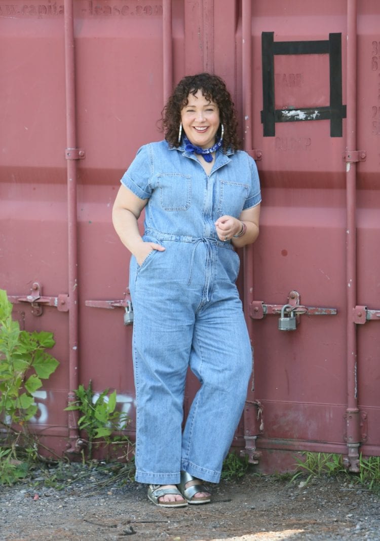 Woman in a short sleeve denim jumpsuit from Levi's styled with a blue bandana, silver Jenny Bird hoops, and silver Birkenstock sandals