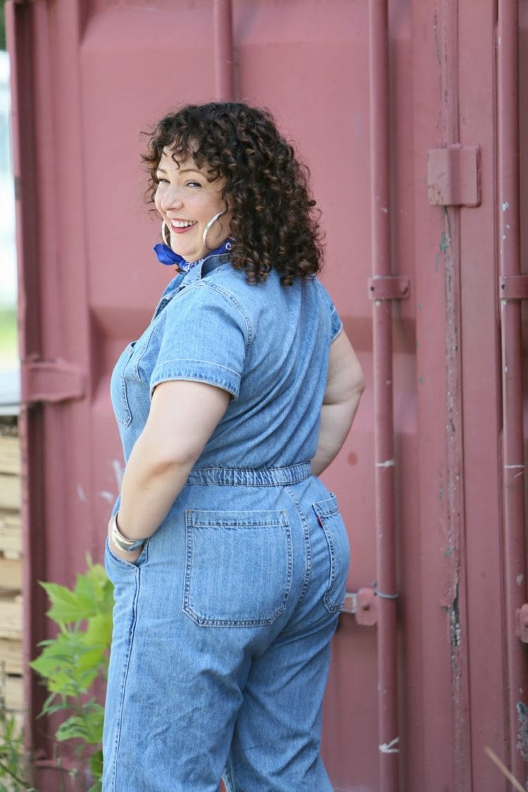 Woman in a short sleeve denim jumpsuit from Levi's styled with a blue bandana, silver Jenny Bird hoops, and silver Birkenstock sandals