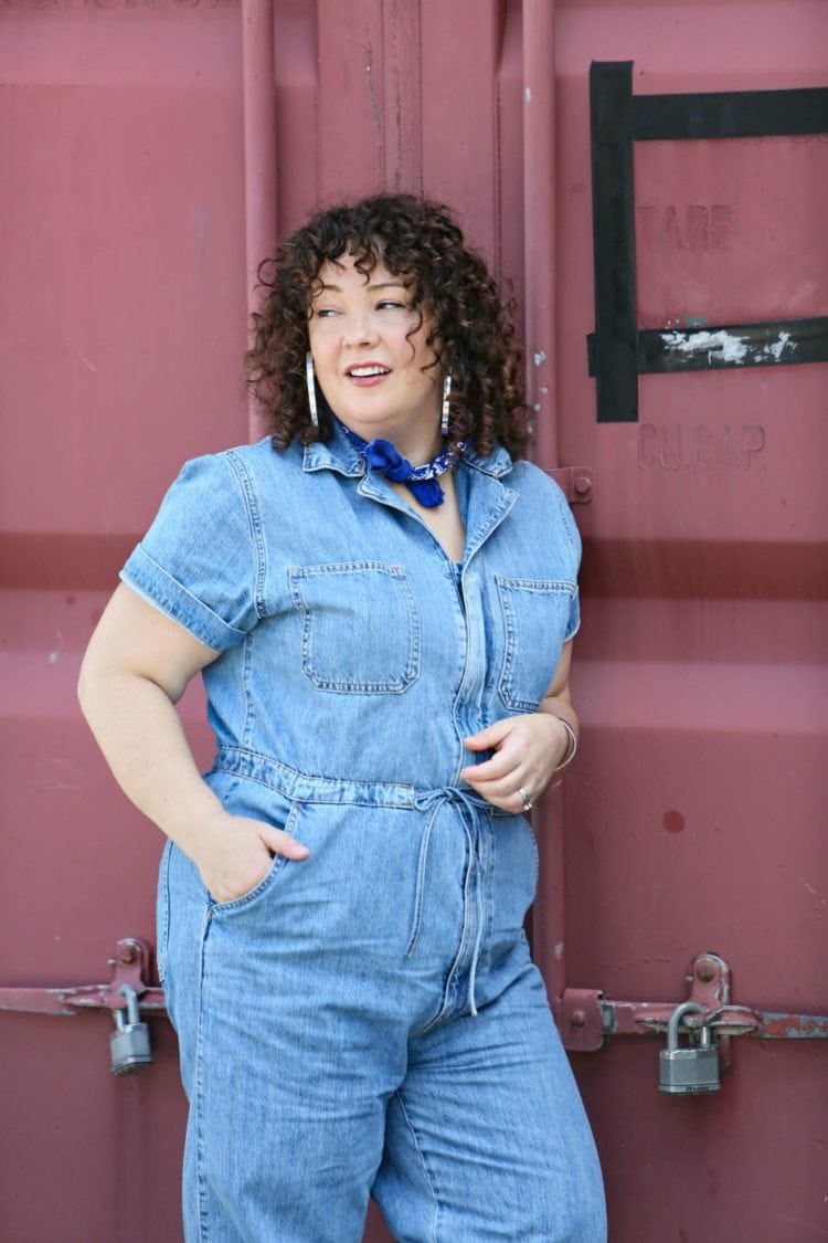 Woman in a short sleeve denim jumpsuit from Levi's styled with a blue bandana, silver Jenny Bird hoops, and silver Birkenstock sandals