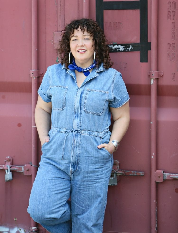 Woman in a short sleeve denim jumpsuit from Levi's styled with a blue bandana, silver Jenny Bird hoops, and silver Birkenstock sandals