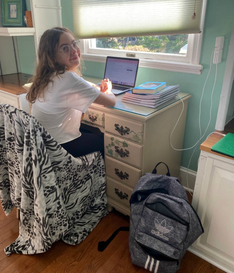 child sitting at a desk in front of a computer with a window overlooking the Atlantic Ocean