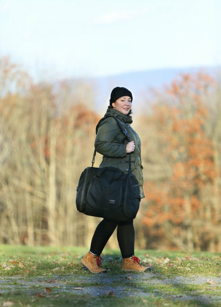 Why The TOM BIHN Aeronaut 45 is Still My Favorite Luggage 10 Years Later 1 An over 40 woman carrying the Tom Bihn Aeronaut 45 with the shoulder strap.