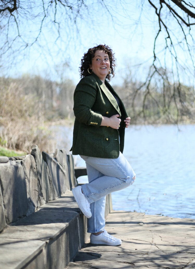 Wardrobe Oxygen in a green tweed double breasted blazer standing next to a lake