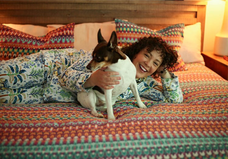 Alison lying on her bed snuggling with her dog