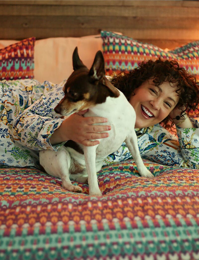 Alison lying on her bed snuggling with her dog