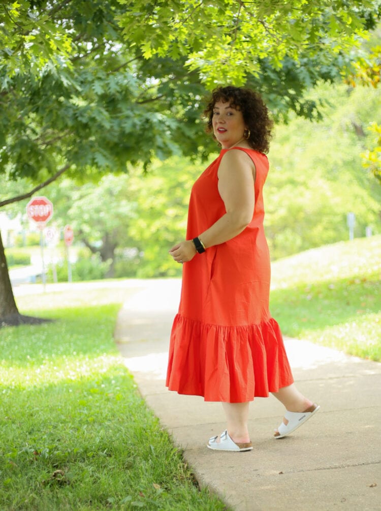 Alison wearing the Christopher John Rogers for Target Orange Shift Dress. She is facing to the left but looking at the camera and smiling. 