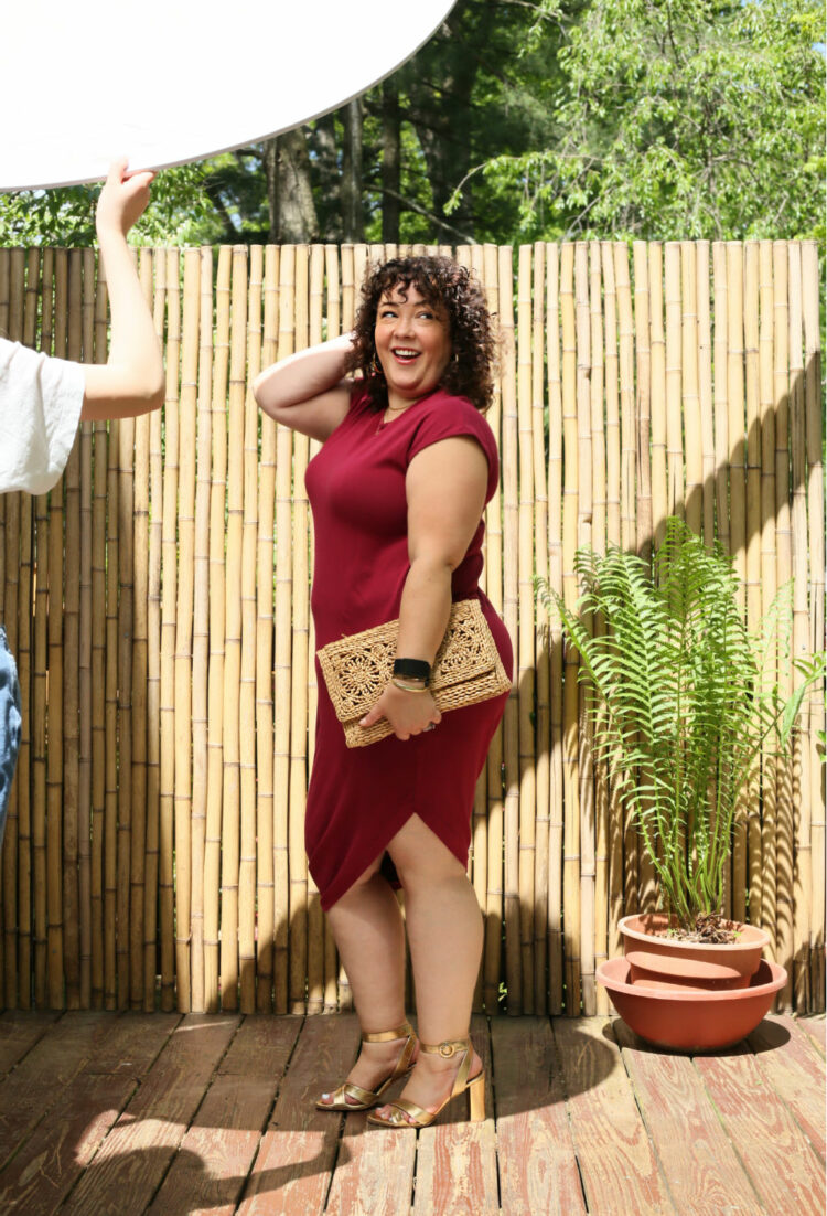 Styling the Universal Standard Geneva Dress for Day and Night 1 Alison Gary of Wardrobe Oxygen in the Universal Standard Iconic Geneva Dress in dark red. She has it styled for a night out with a clutch and heeled sandals.
