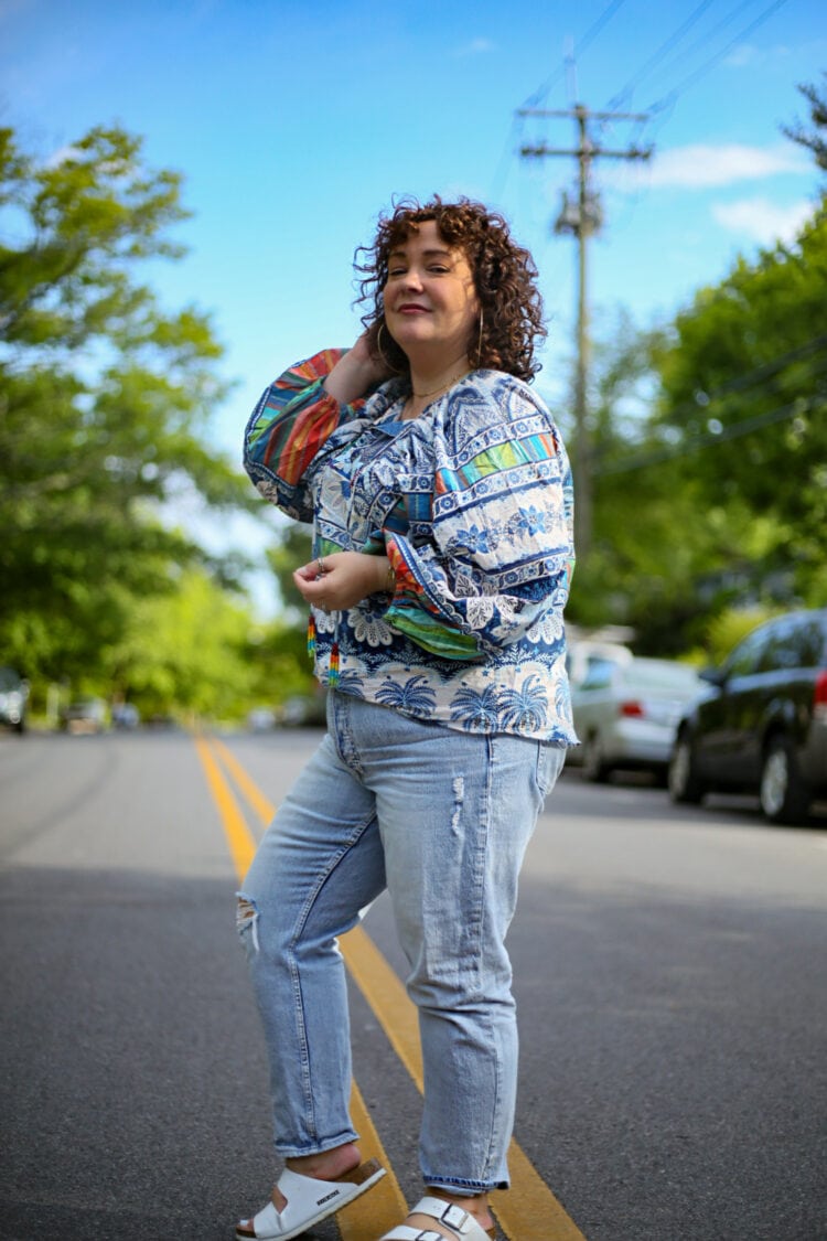 Alison looking at the camera but walking to the left in a Farm Rio top and Gap jeans