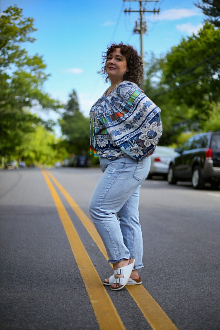 Alison in a Rarm Rio top and Gap jeans facing the left and turning her face to the camera