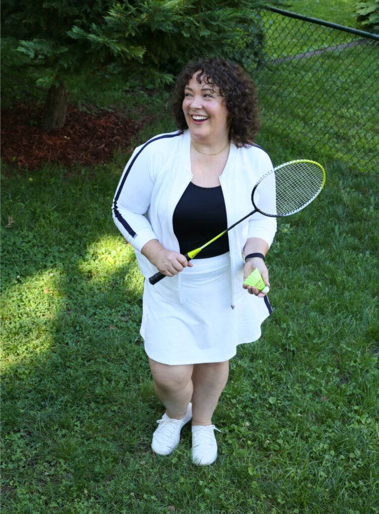 Alison in the Talbots On the Move skort and bomber holding a badminton racket and birdie