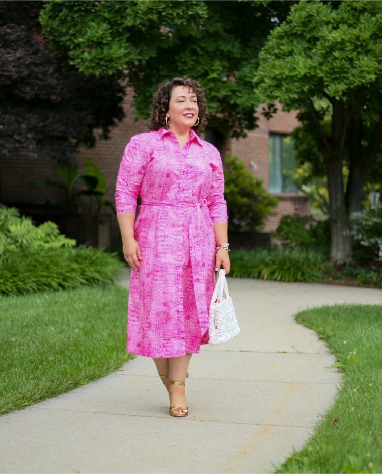 Pink poplin shirtdress from Chico's as seen on Alison of Wardrobe Oxygen. She has it belted and styled the dress with a vintage white crocheted frame purse and gold Margaux Uptown Sandals