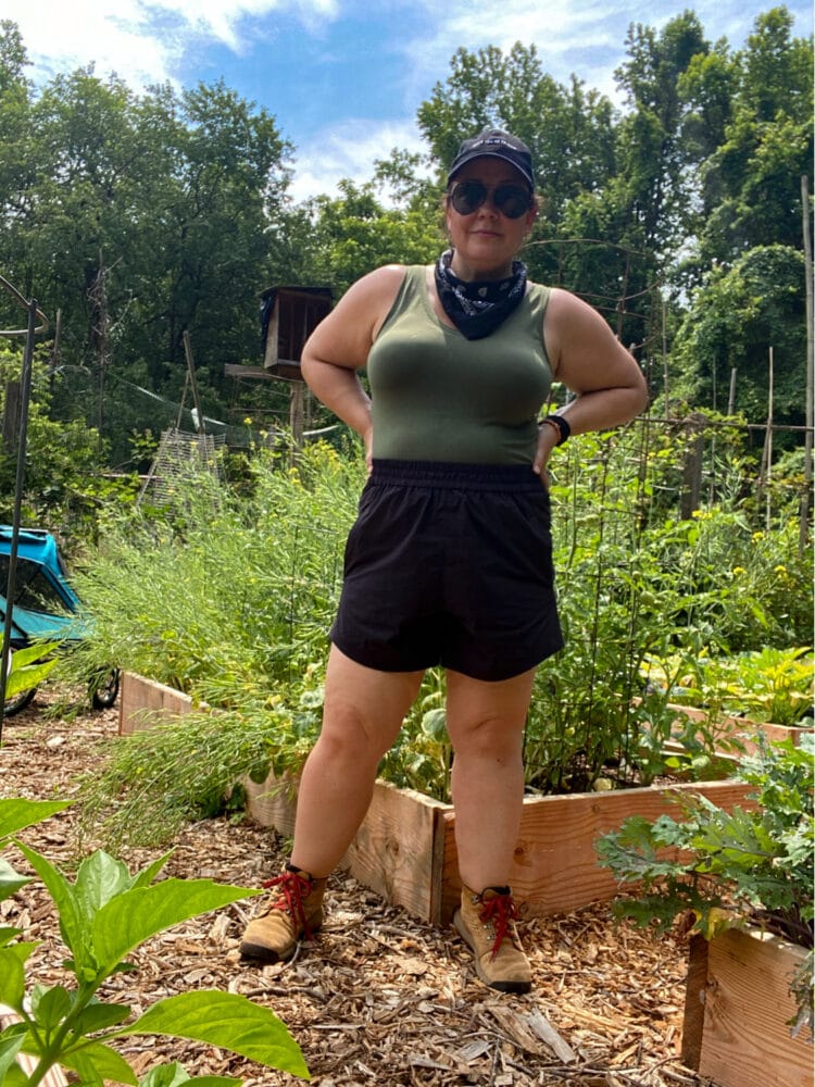 Wearing the Universal Standard Sunny shorts in black in my garden. They are styled with a navy v-neck tank, black bandana and tan Danner hiking boots