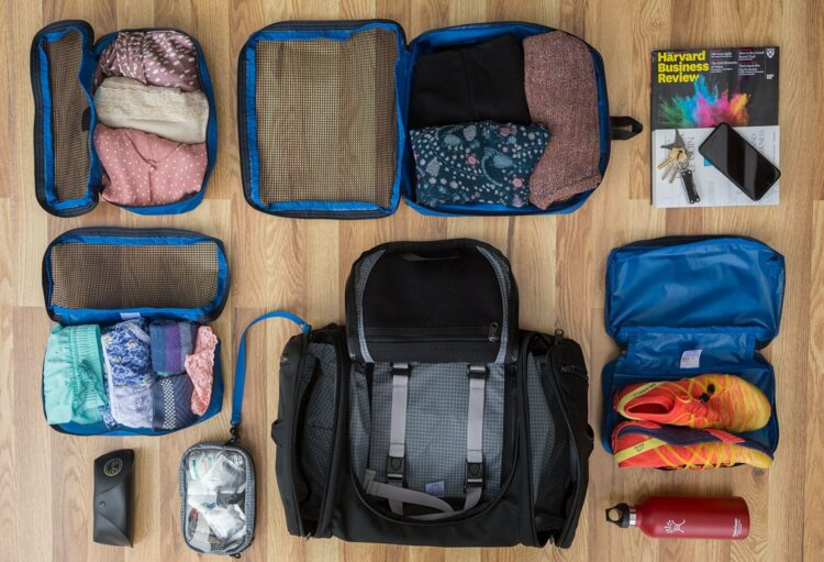 The Tom Bihn Aeronaut bag with packing cubes half-packed circled around it.