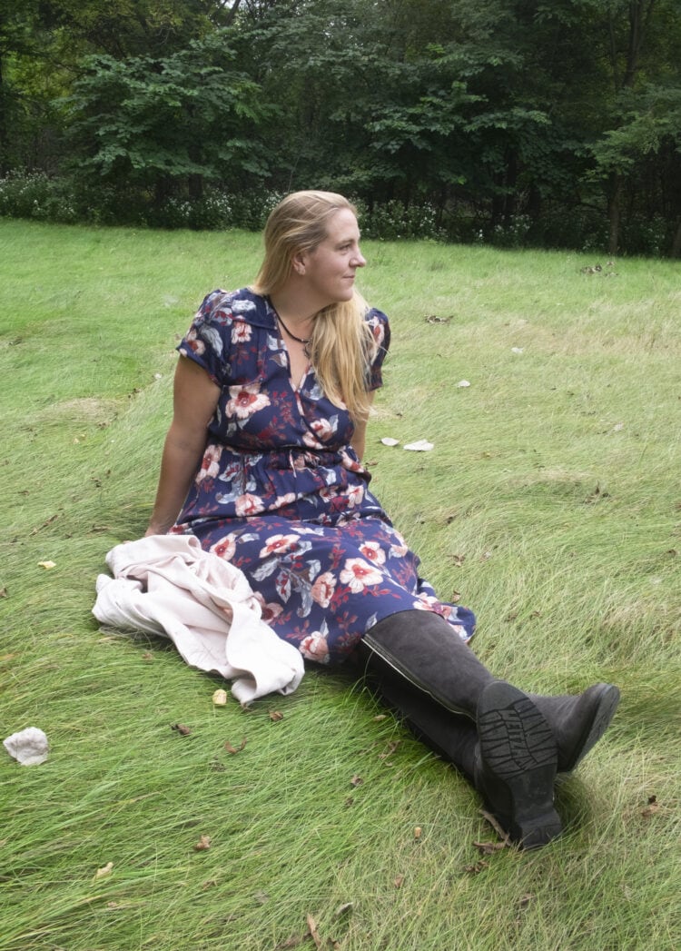 Woman with long blonde hair in the navy floral Dawn dress from Christy Dawn