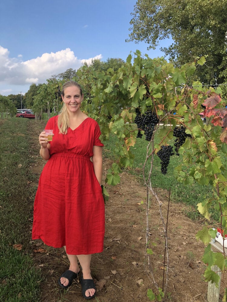 Woman in a red mini length dress and black sandals at a winery