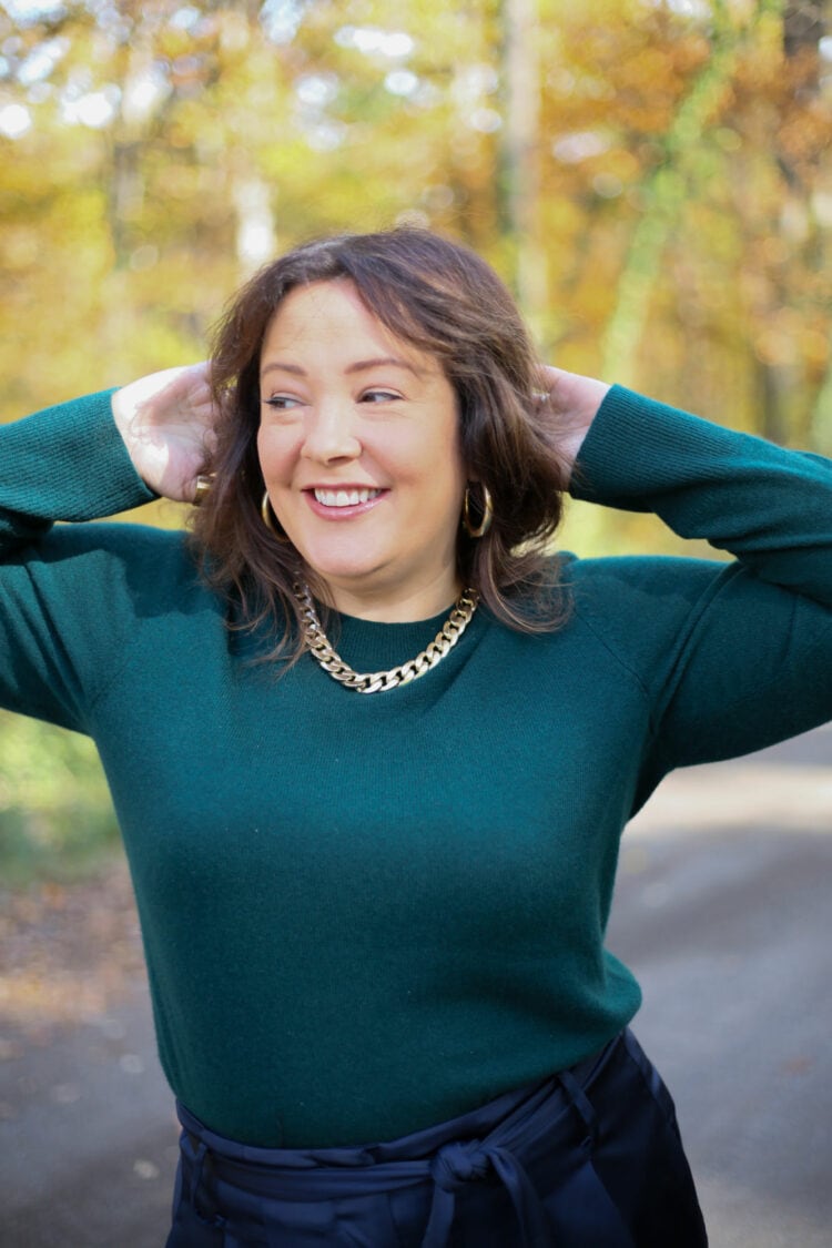 Alison has her hands up on her head to show the underarms of this green cashmere sweater from Universal Standard. There are not fuzzballs or pilling on the sweater.