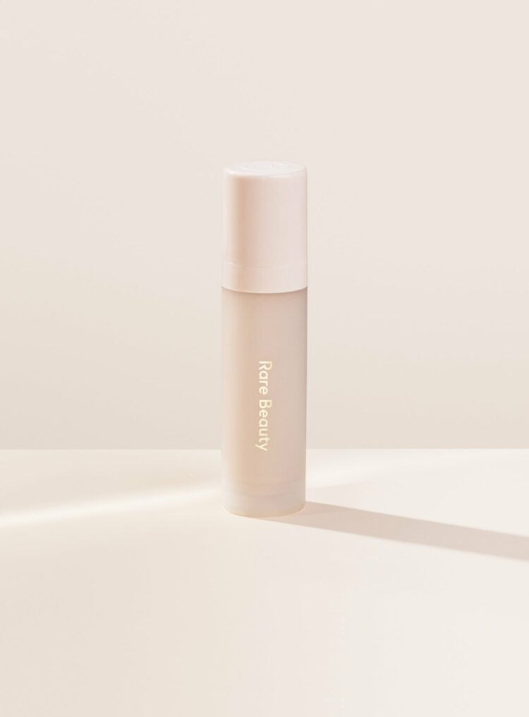 Rare Beauty's Always an Optimist Illuminating Primer bottle on a white background.