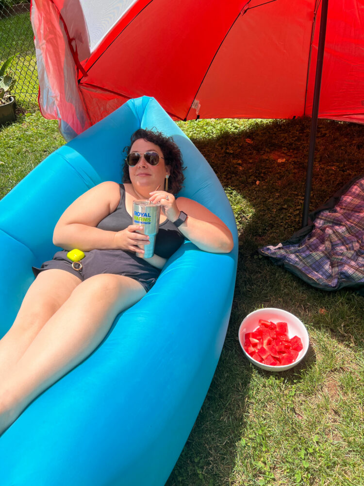 Alison Gary of Wardrobe Oxygen lying on a Fatboy lounger, sipping a beverage from a Royal Farms stainless tumbler