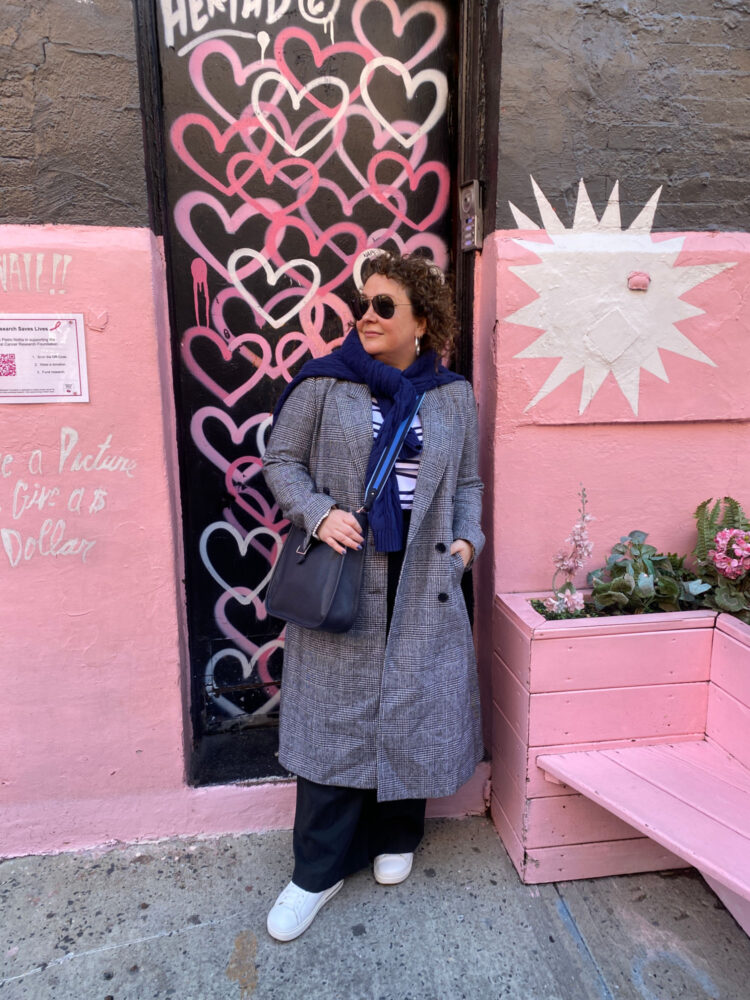 Stylish Wide Width Shoes for Fall 2026: Best Wide-Foot Friendly Styles + Fit Tips 7 alison gary of wardrobe oxygen wearing wide width travel sneakers for fall 2026 with gray trousers and a plaid overcoat
