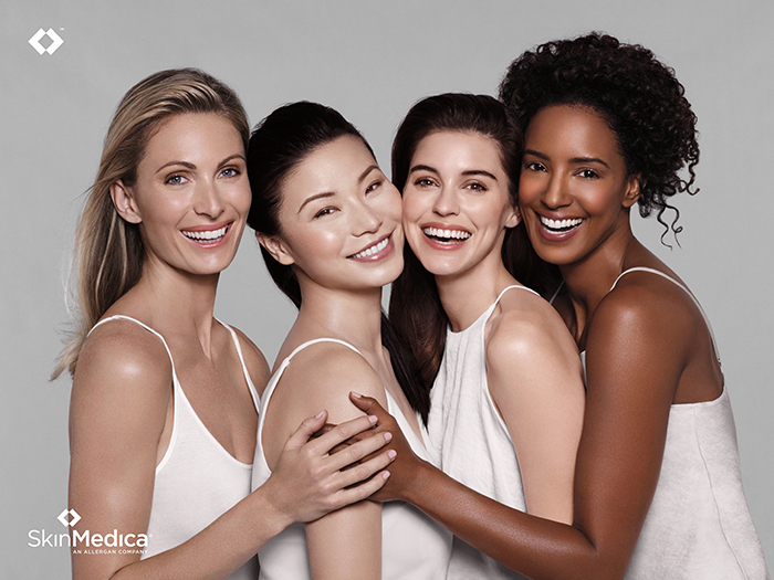 Image of four models in white hugging each other. Overlay of the SkinMedica name and logo. This is used to begin an honest skinmedica review and the reaction and rash I got by Wardrobe Oxygen
