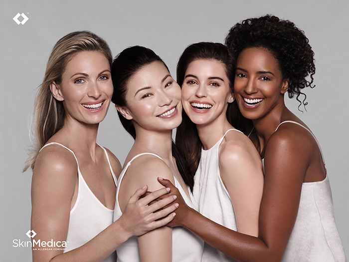 An Honest SkinMedica Review 1 Image of four models in white hugging each other. Overlay of the SkinMedica name and logo. This is used to begin an honest skinmedica review and the reaction and rash I got by Wardrobe Oxygen