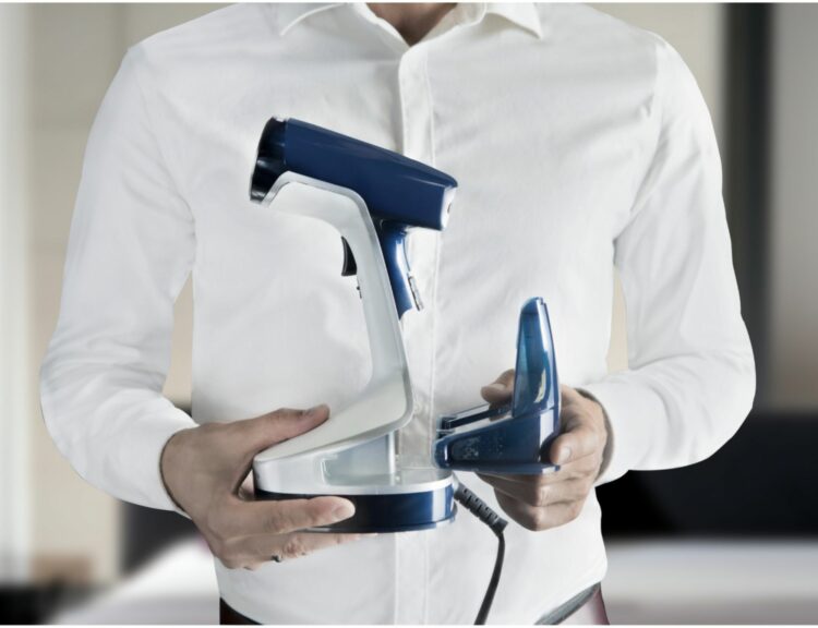 man holding the rowenta handheld steamer