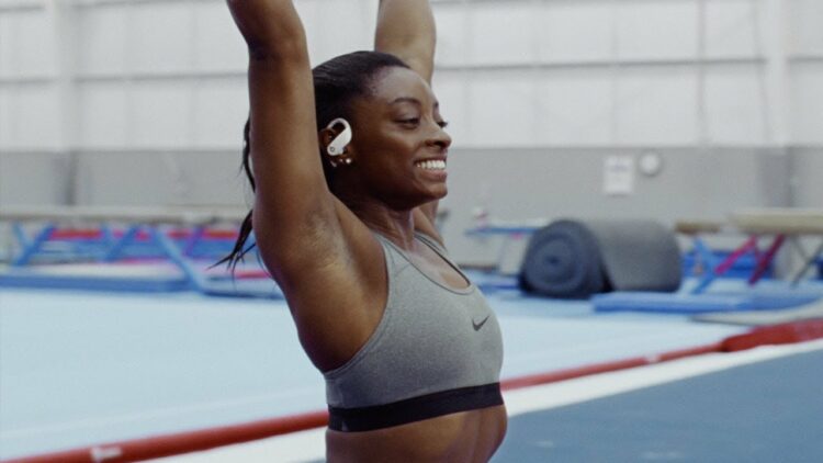 Simone Biles wearing the Beats By Dre Powerbeats Pro earbuds