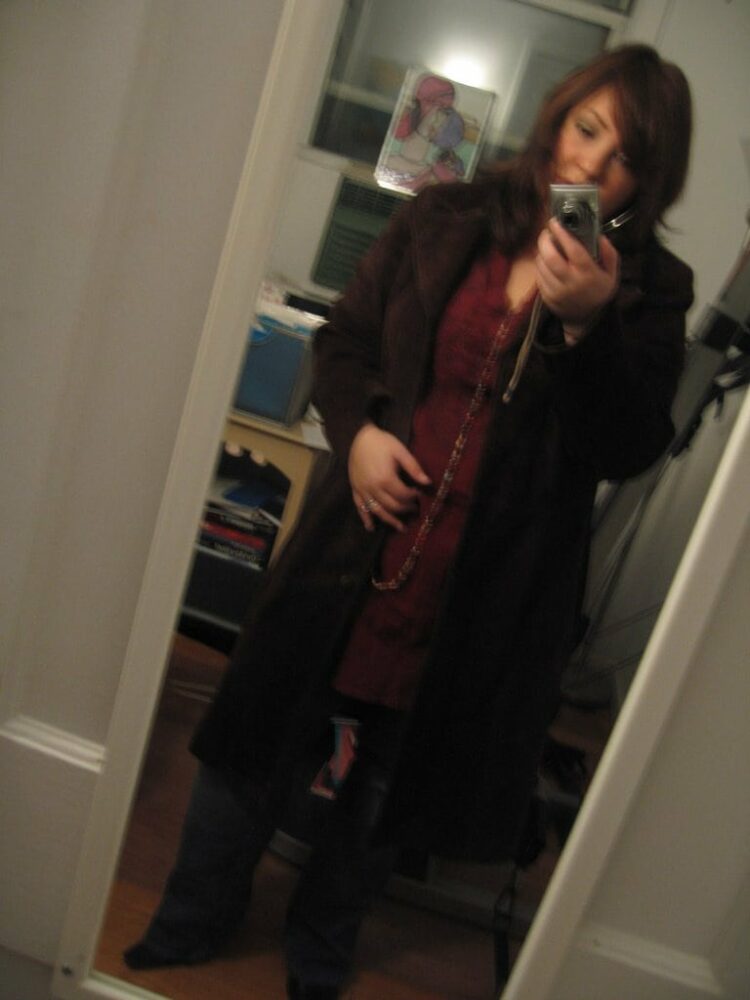 Alison Gary of Wardrobe Oxygen in 2008 taking a mirror selfie wearing a long brown suede coat from Express over a burgundy crinkle tunic and bootcut jeans.