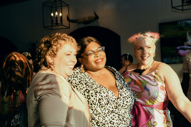 three women smiling and posing to get their photo taken.