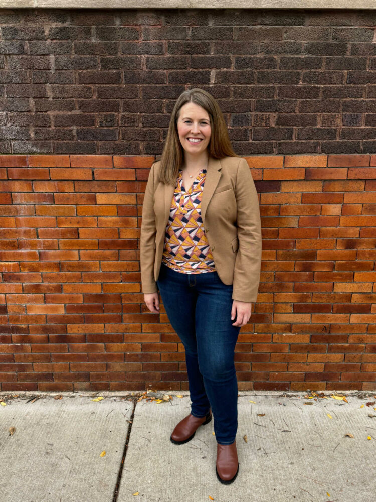 Woman in a tan blazer and printed shell over dark straight leg jeans styled with Poppy Barley Chelsea boots