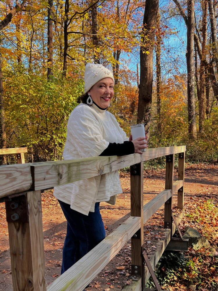 Alison of Wardrobe Oxygen in a winter white beanie, beaded earrings, and poncho all from T.J.Maxx