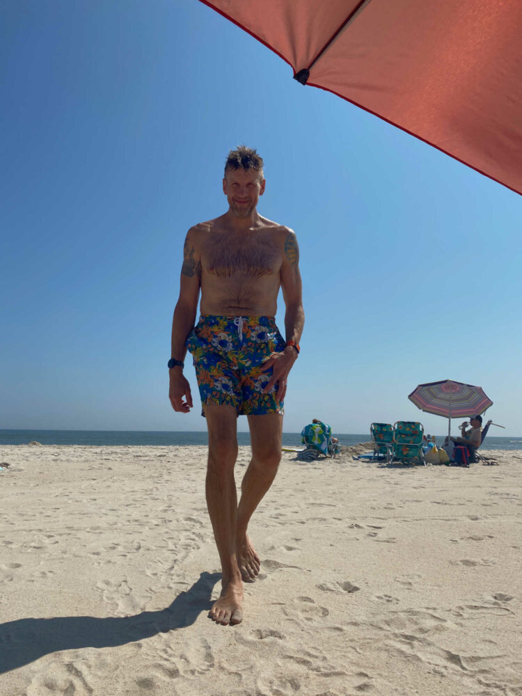 man in Lands End Volley Swim Trunks on the beach at Fire Island