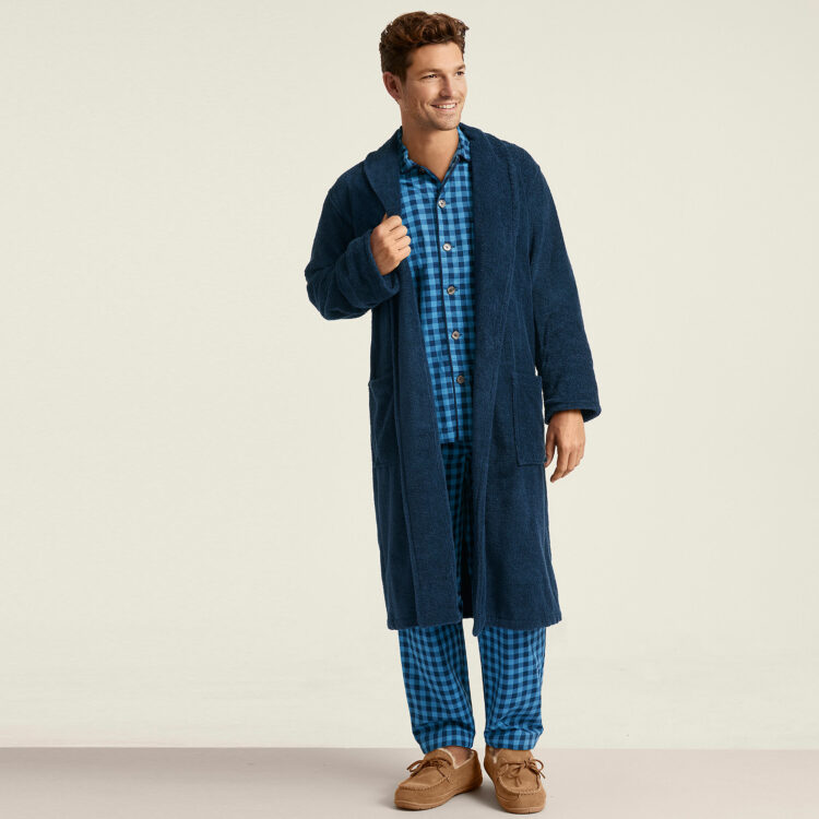 a man wearing the calf length Lands' End Turkish Terry robe in navy over plaid pajamas