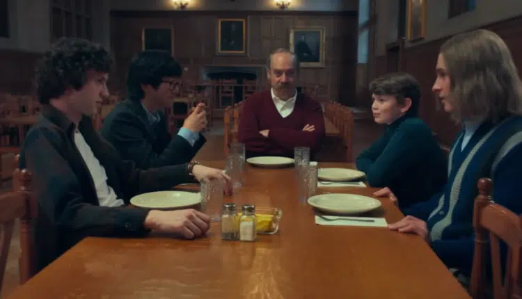 scene from the movie The Holdovers where Paul Giamatti is sitting at a table with several student from the prep school